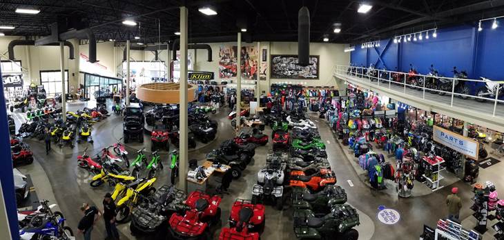 An aerial view of the showroom floor full of brightly colored ATVs and dirt bikes.